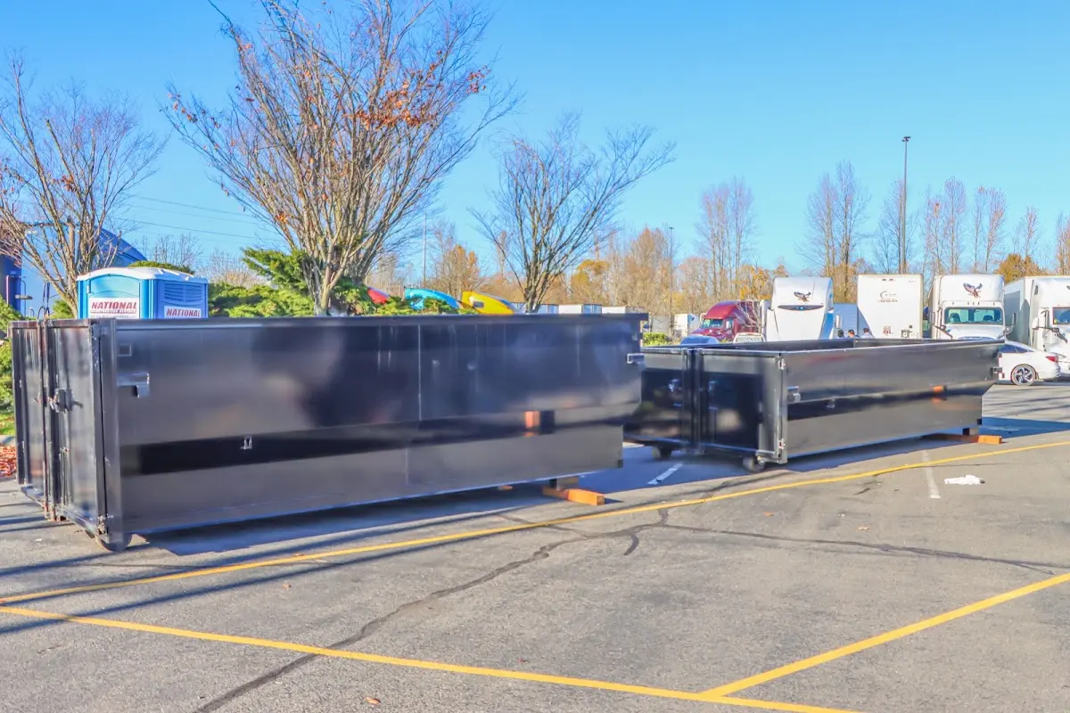 Professional dumpster rental service with roll-off container on residential driveway in Conroe